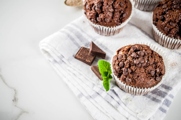 Home baked mint and chocolate muffins with mint tea, white marble background copy space