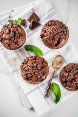 Home baked mint and chocolate muffins with mint tea, white marble background copy space