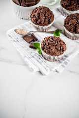 Home baked mint and chocolate muffins with mint tea, white marble background copy space