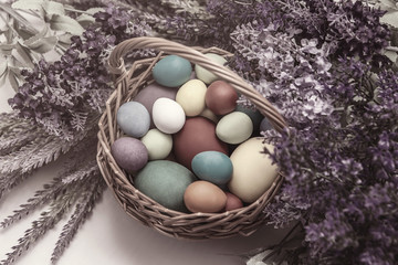 Vintage easter eggs in a basket with lavender flowers