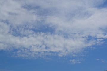Background of a blue light sky with shallow clouds. Light tone of the summer sky. Light airy nature.