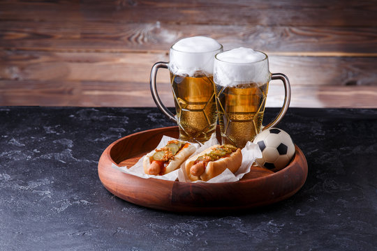 Picture of two glasses of beer, hot dogs, soccer ball