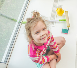 child on the windowsill washes the window © dmitrypk