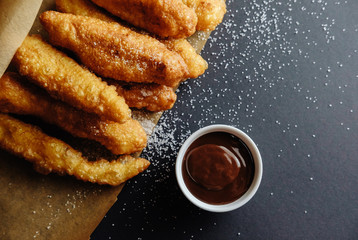 small homemade pies on black background cup with chocolate bakery paper scattered sugar on the table