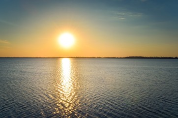 Obraz premium Sunny summer landscape. Beautiful sunset on the lake.