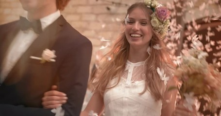 Guests throwing confetti at bride and groom leaving church