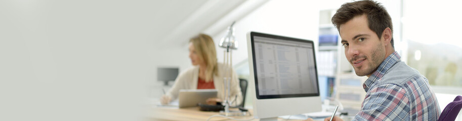 Smiling office worker sitting at desk, template