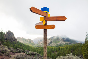 Blank directional road signs on mountains background. Choice concept