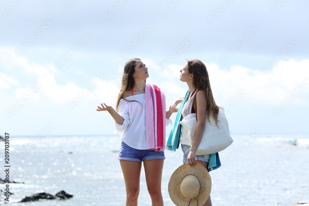 Wall mural frustrated tourists complaining about poor weather on the beach