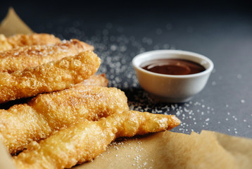 small homemade pies on black background cup with chocolate bakery paper scattered sugar on the table