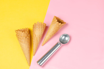 Ice cream waffle cones over sweet pink and light yellow background with scoop and copy space for text, logo or wordings insertion or decoration, summer cold sweets