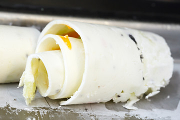 Roll ice cream is made by hand on the freezer. Sweet dessert made from natural berries and ingredients.