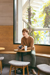 Young Asian man using smart phone during having breakfast, coffee time and summer holiday vacation concepts