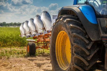 Foto op Plexiglas tractor with plough beside the field © ronstik