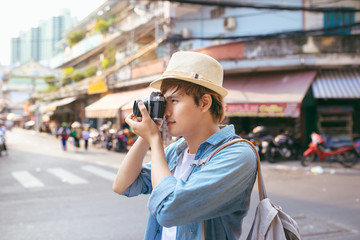 Young woman with camera photographing at the street