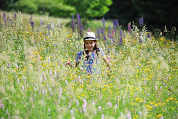 Ein Mädchen steht in einer wilden Blumenwiese im Thüringer Wald