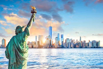 Photo sur Plexiglas Statue de la Liberté Statue de la liberté et les toits de la ville de New York au coucher du soleil