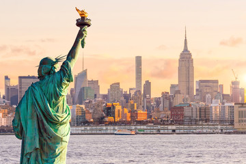 Statue de la liberté et les toits de la ville de New York au coucher du soleil