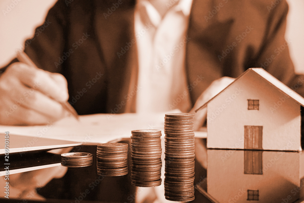 Wall mural brown theme stack of money on working table with background business man.