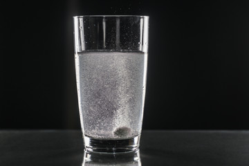 Glass of water and pills isolated on white