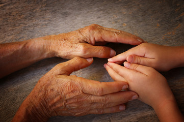 Fototapeta premium image of old man and a kid holding hands together.