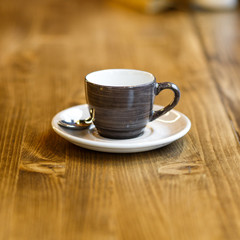 Empty gray cup with a spoon in a cafe on a wooden table