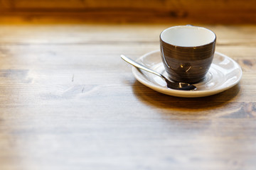 Empty gray cup with a spoon in a cafe on a wooden table