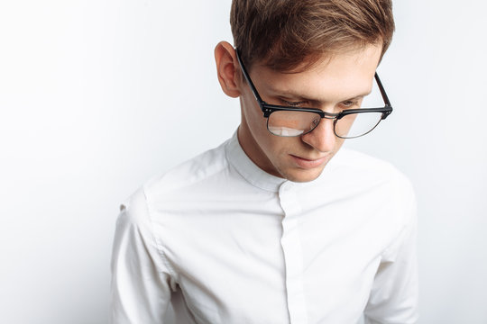 Portrait of young attractive guy in glasses, in white shirt, isolated on white background, for advertising, text insertion