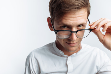 Portrait of young attractive guy in glasses, in white shirt, isolated on white background, for advertising, text insertion