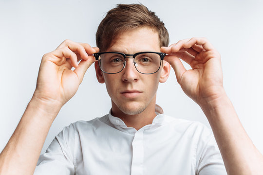 Portrait of young attractive guy in glasses, in white shirt, isolated on white background, for advertising, text insertion