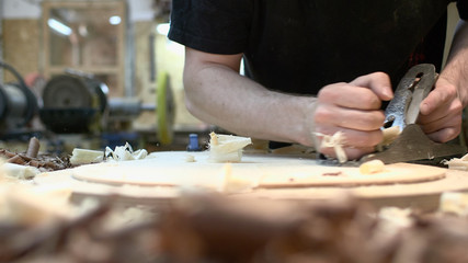 The guitar master scribbles Soundboard of the future classical guitar with a plane.