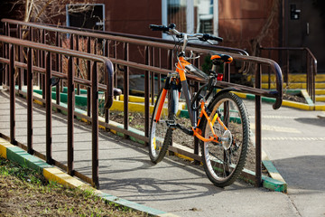 A sport bike is tied to the fence on a sunny day in spring and summer. Back view