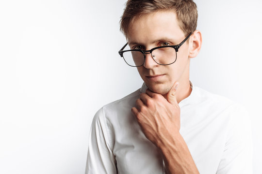 Portrait of young attractive guy in glasses, in white shirt, isolated on white background, for advertising, text insertion