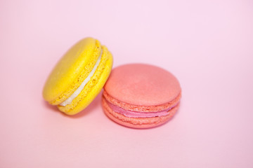 Raspberry and yellow lemon french macaroon on pink background