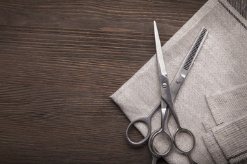 Hairdressing scissors on a black wood background.