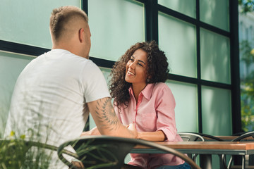 Obraz premium Close up on a man and a woman holding hands at a wooden table