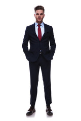 Fototapeta premium handsome relaxed businessman in navy colored suit standing