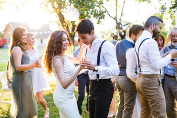 Guests dancing at wedding reception outside in the backyard.