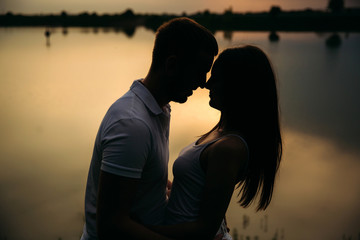 Silhouette of beautiful couple. lake in background