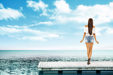 Summer time and slim woman on pier. Sea landscape with blue sky. 