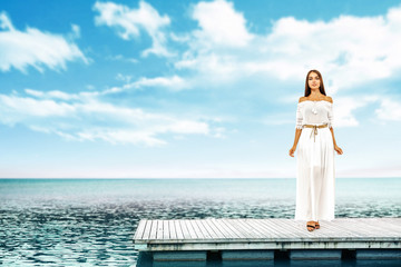 Summer time and slim woman on pier. Sea landscape with blue sky. 