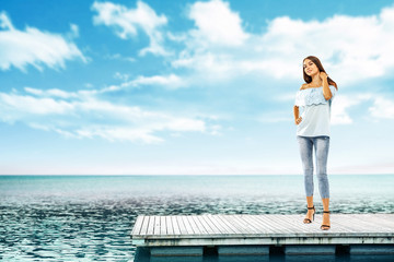 Fototapeta premium Summer time and slim woman on pier. Sea landscape with blue sky. 