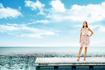 Summer time and slim woman on pier. Sea landscape with blue sky. 