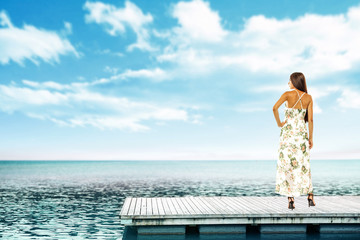 Summer time and slim woman on pier. Sea landscape with blue sky. 