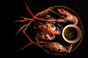 grill shrimp with seafood sauce on the black wooden table