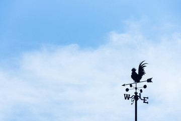 Rooster weather vane on blue sky