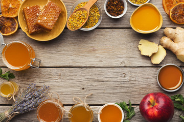 Various types of honey on old wooden background