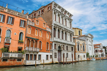 Fototapeta na wymiar View of ancient buildings and church facing the Grand Canal, at the city center of Venice, the historic and amazing marine city. Located in Veneto region, northern Italy