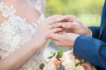 Obraz na płótnie Canvas Closeup of engagement scene. Groom puts ring on the bride finger