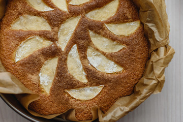 Top view of a homemade dessert from apple pie in a baking dish ready for use on a wooden background
